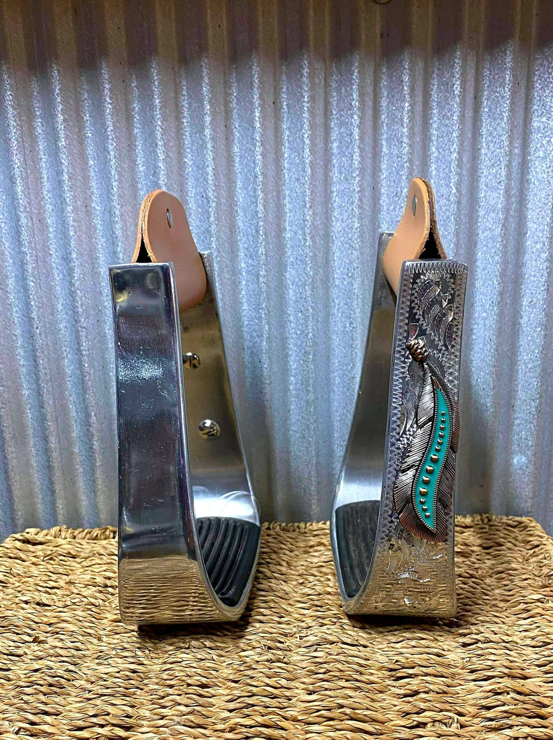 Stirrups - ®   Silver Engraved Stirrups with copper and teal feather concho on top of the engraved side.